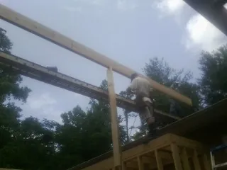 Carpenter setting a ridge beam over a new addition frame — Ice Dam Removal by Roofing Brothers in Darrington