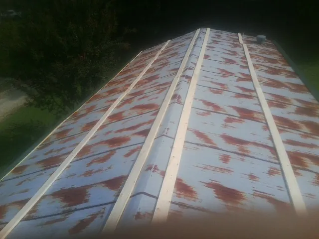 Rusted metal roof panels with new wood purlins before replacement — Storm Damage Roof Repair in Darrington by Roofing Brothers
