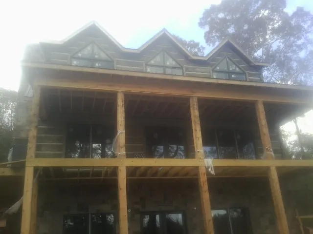 Dormers and porch framing on a large log home under construction — Roof Coating work by our crew in Darrington