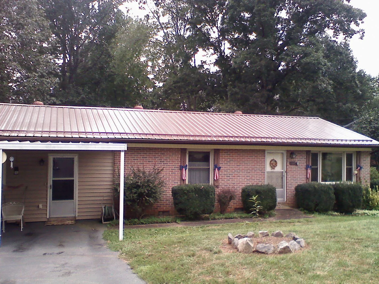 Bronze metal roof and carport on a brick ranch home — Roof Repair work by our crew in Darrington